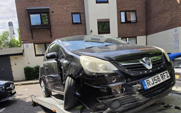 Black Opel Vauxhall car with front damage on recovery flatbed