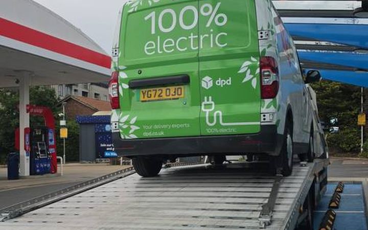Green electric DPD delivery van recovered on flatbed truck