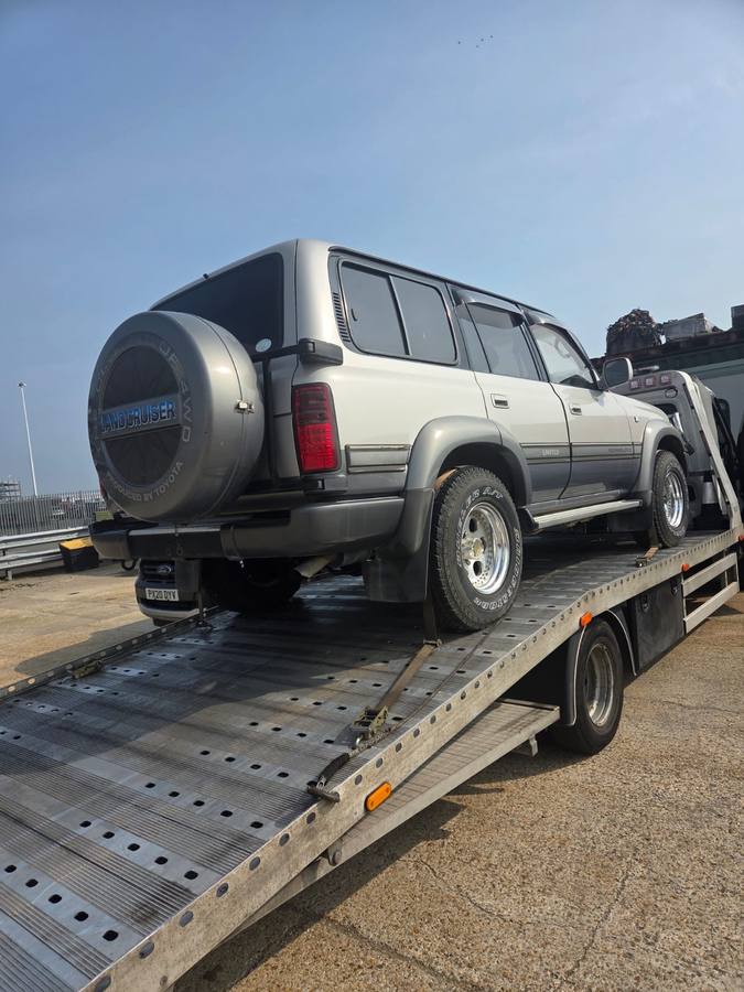 Mitsubishi Shogun SUV transported on recovery truck flatbed in daylight