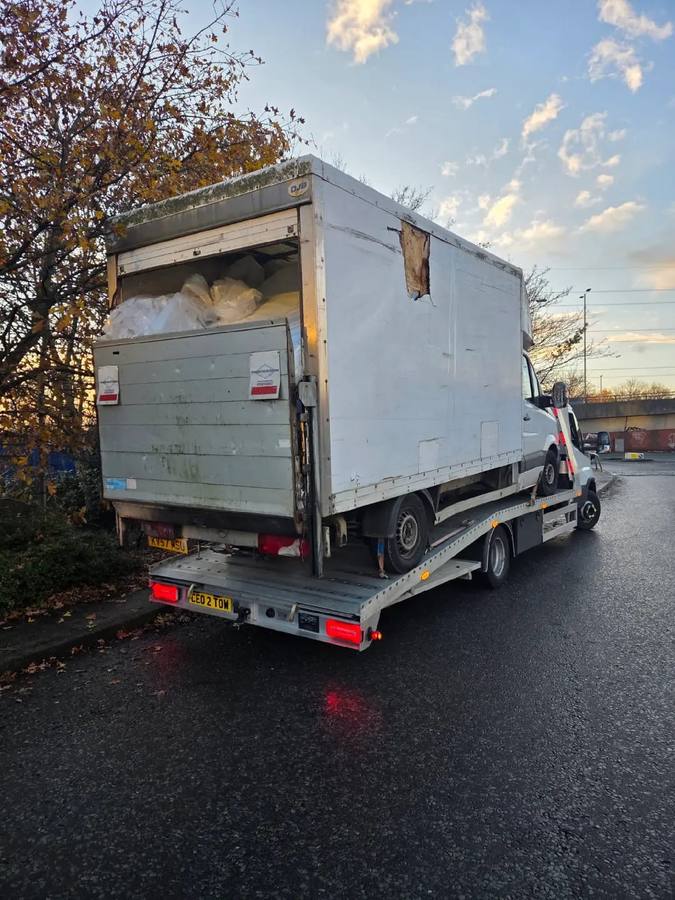 White commercial box van recovered and loaded on flatbed truck