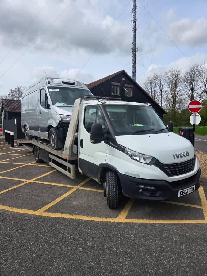 Iveco recovery truck carrying Mercedes commercial van on flatbed