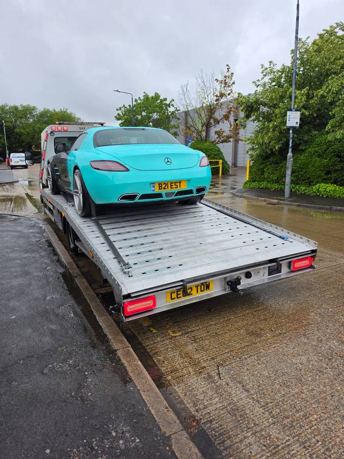 Turquoise Mercedes sports coupe on recovery truck flatbed