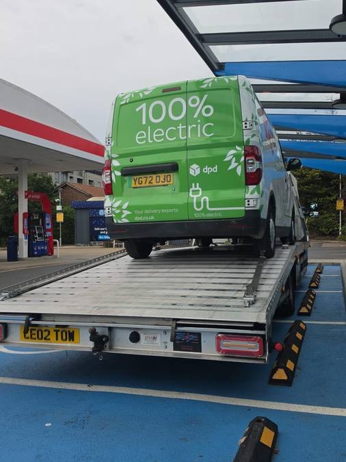 Green electric DPD delivery van recovered on flatbed truck