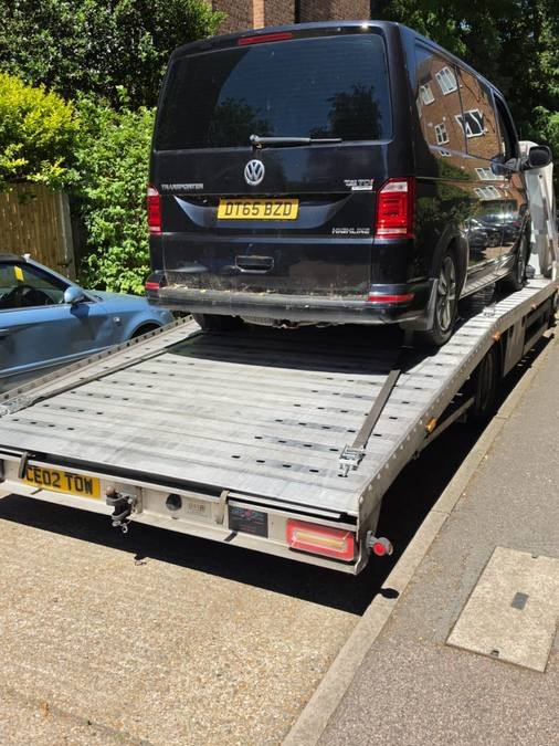 Black Volkswagen Transporter van recovered on truck flatbed