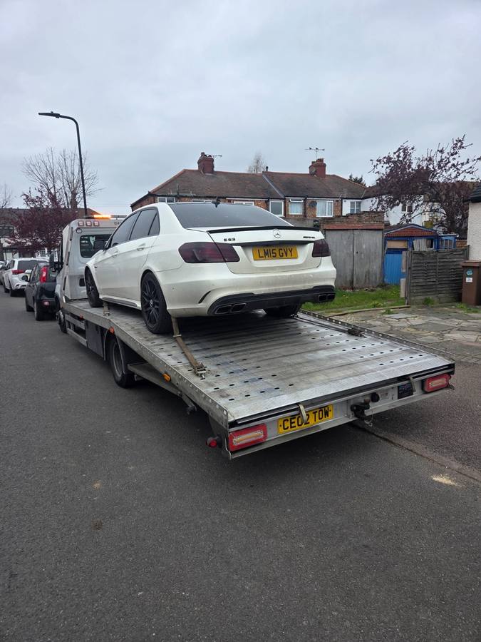 White Mercedes sedan on Tow 2 Tow flatbed at residential suburban street