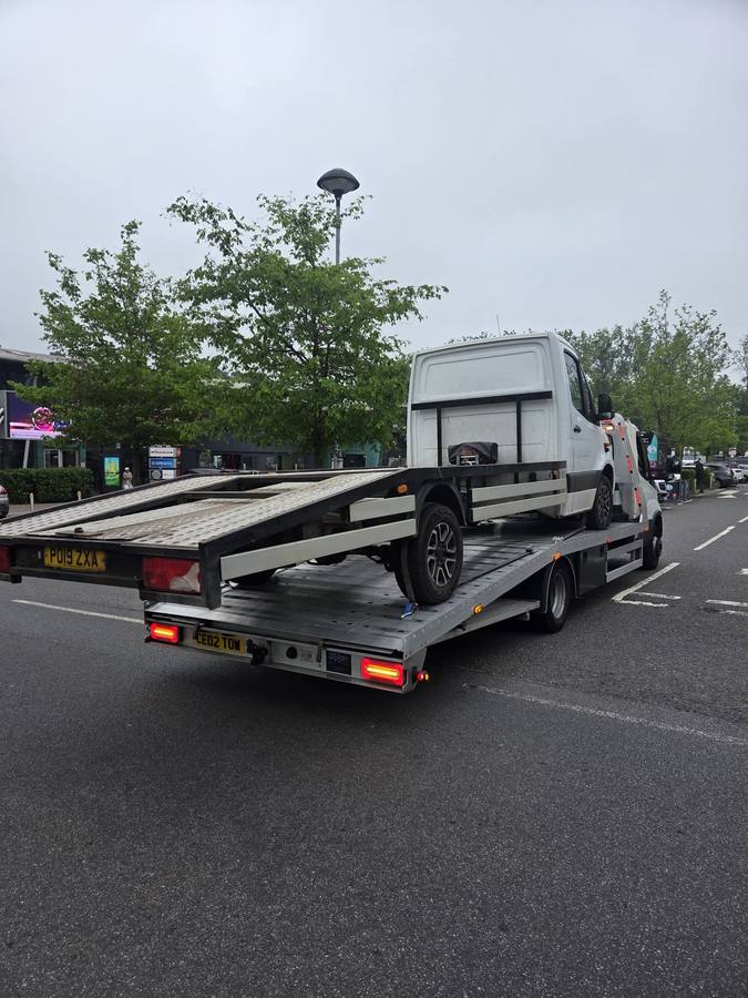 Light grey commercial van on Tow 2 Tow flatbed at car park outdoor site