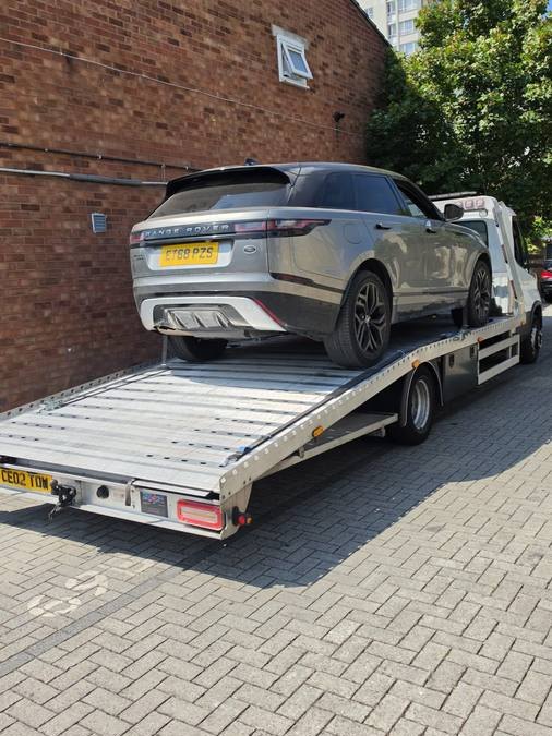 Silver Range Rover Evoque luxury vehicle on recovery flatbed with excellent lighting