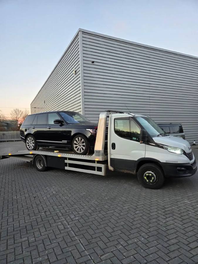 Black Range Rover SUV loaded on Iveco recovery truck with excellent composition